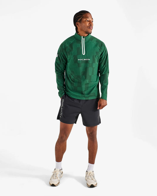 Person wearing a green athletic jacket with a brand logo on a white background